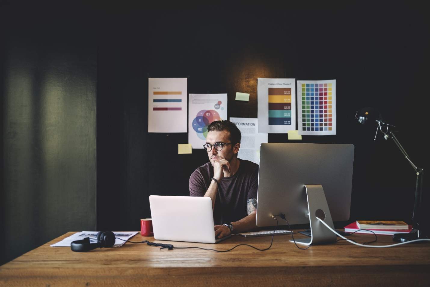 A person sitting at a desk with a computer and microphone Description automatically generated with medium confidence